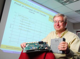 GTRI researcher Mike Willis displays the newly patented digital crystal video receiver, 2007.